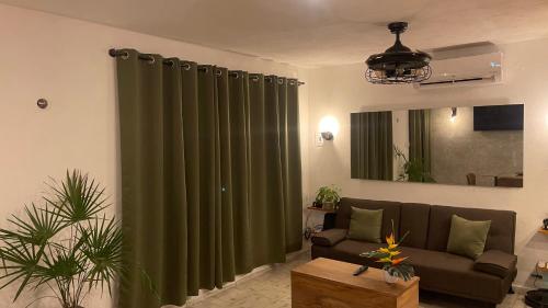 a living room with a couch and a green curtain at INDUSTRIAL.SMART HOME in Mérida