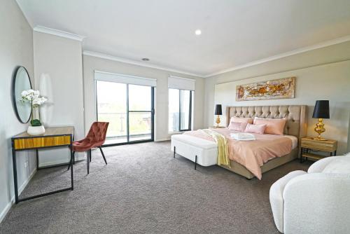 1 dormitorio con cama, escritorio y silla en Wyndham 5BR Spacious Holiday Vacation Home WiFi, en Truganina