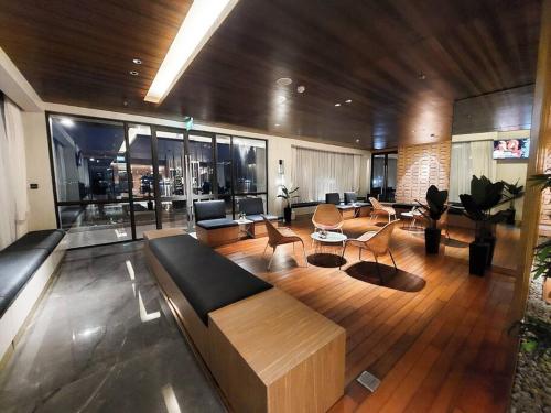 a living room with a couch and chairs in a building at One Residence Apartment 2BR near Ferry Terminal in Batam Center