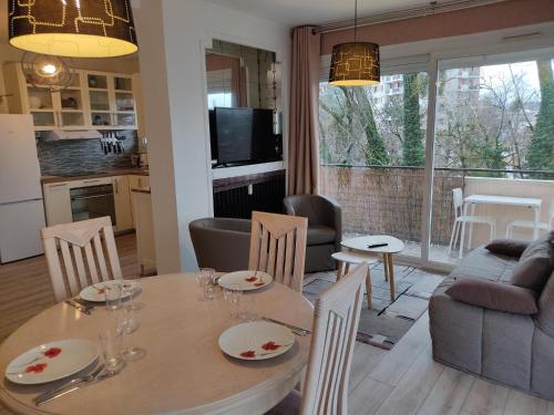 une cuisine et un salon avec une table et des chaises dans l'établissement Charmant appartement au bord du Thiou - Annecy, à Annecy