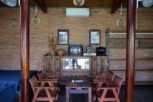 uma sala de estar com uma televisão e uma mesa e cadeiras em Homestay Hơ Đơng em Plây Ku