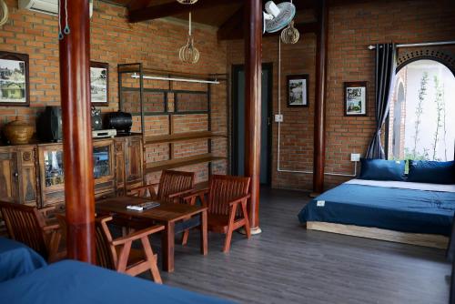 um quarto com uma cama, uma mesa e cadeiras em Homestay Hơ Đơng em Plây Ku