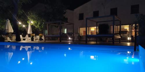 uma piscina à noite com iluminação azul em Sant Roc em Montseny