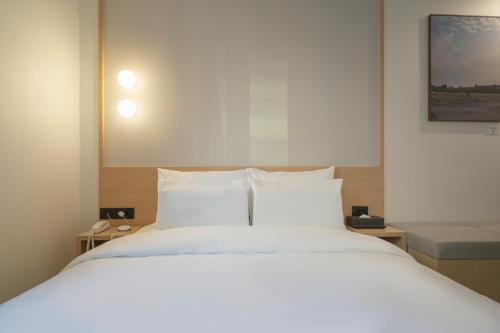 a bedroom with a large white bed with white pillows at Aank Hotel Cheonan Station 1st in Cheonan