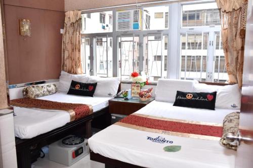 a room with two beds and a window at Toronto HK in Hong Kong