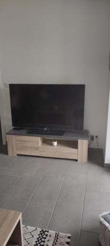 uma sala de estar com uma grande televisão de ecrã plano em Lilas em Giromagny