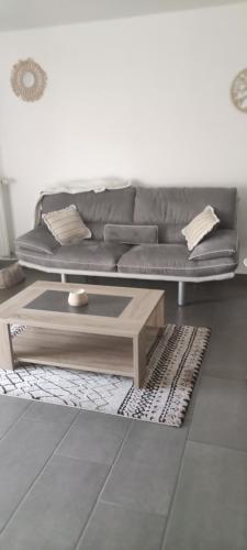 uma sala de estar com um sofá e uma mesa de centro em Lilas em Giromagny