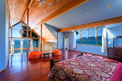 a bedroom with a bed in a room with windows at Gorgeous Oceanview, by OceanviewHotTubs Oceanfront! Shelter Cove, CA Tesla EV Station in Shelter Cove