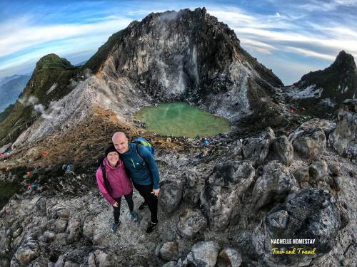 a man and a woman standing on top of a mountain at Nachelle Homestay in Berastagi