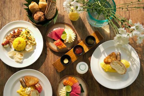 a wooden table topped with plates of food at Alila Ubud in Ubud