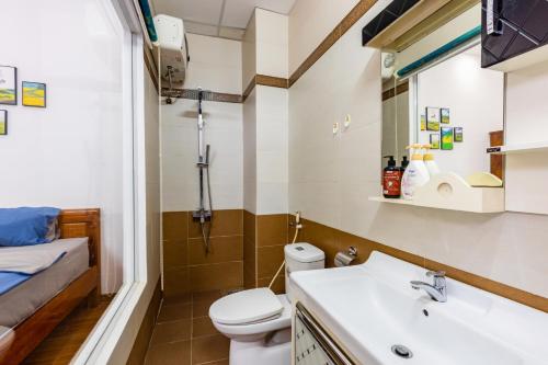 y baño con aseo y lavamanos. en Simple House Near My Khe Beach and Night Street en Da Nang