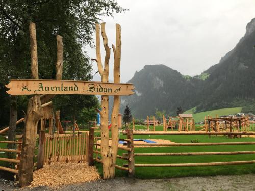 a sign on a fence in front of a playground at monas home mayrhofen in Mayrhofen