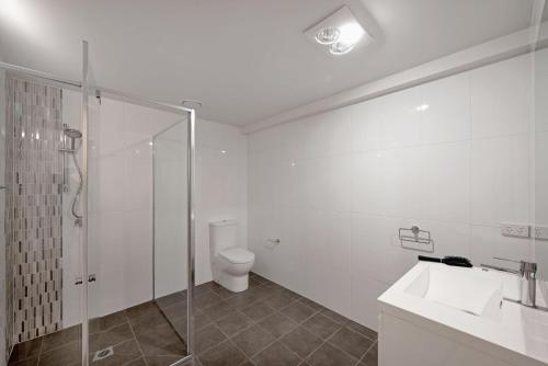 ein Bad mit einer Dusche, einem WC und einem Waschbecken in der Unterkunft The Menzies Suite in Canberra