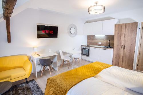 a bedroom with a yellow bed and a kitchen at Boutique Apartments Old Town in České Budějovice
