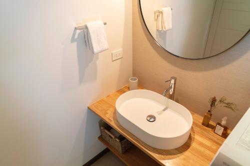 W łazience znajduje się biała umywalka i lustro. w obiekcie YAMO-Kawana Ippekiko w mieście Ogi