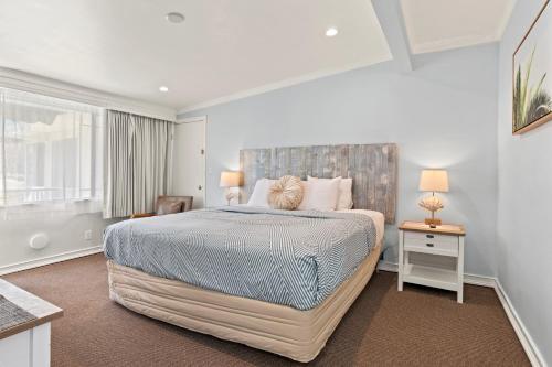 ein Schlafzimmer mit einem großen Bett und einem Fenster in der Unterkunft Ocean Lodge Santa Monica Beach Hotel in Los Angeles