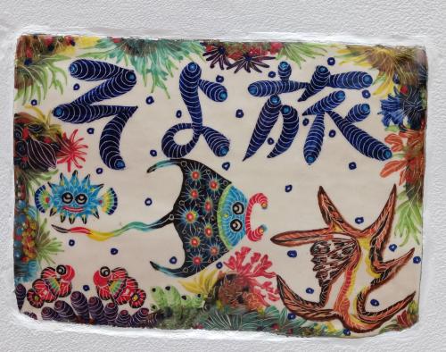 a plate with drawings of birds on it at ゲストハウス そよ旅 Guesthouse Soyotabi in Ishigaki Island