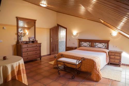 a bedroom with a bed and a dresser and a table at Hotel Rural La Plazuela in Aldealengua