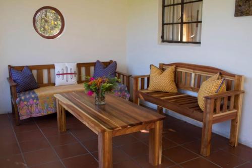 ein Wohnzimmer mit Holzbänken und einem Tisch in der Unterkunft Khayalethu Cottage in Hogsback
