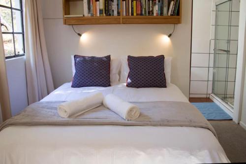 ein Schlafzimmer mit einem Bett mit zwei Kissen in der Unterkunft Khayalethu Cottage in Hogsback