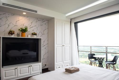 a bedroom with a flat screen tv and a bed at Stay @ Almas Puteri Harbour in Nusajaya
