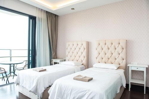 a hotel room with two beds and a table at Stay @ Almas Puteri Harbour in Nusajaya