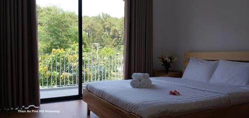 ein Schlafzimmer mit einem Bett mit zwei Teddybären darauf in der Unterkunft Thien An Pine Hill Homestay Hue in Hue