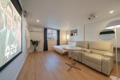a living room with a couch and a bed at Aank Hotel Cheonan Station 1st in Cheonan