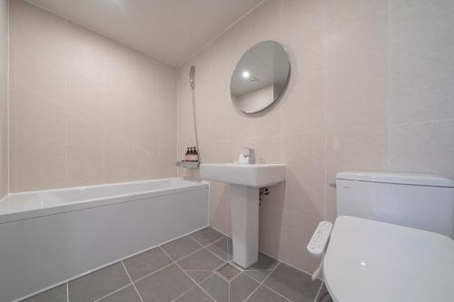a bathroom with a sink toilet and a mirror at Aank Hotel Cheonan Station 1st in Cheonan