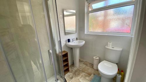 a bathroom with a toilet and a sink and a shower at Cozy coastguard cottage with sea views in East Cowes