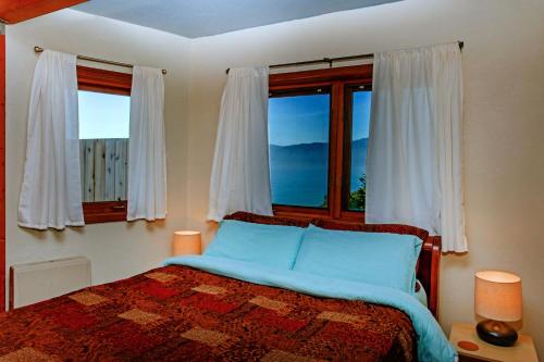 a bedroom with a bed with a view of the ocean at Amazing Oceanview 2 bedroom Oceanfront! by OceanviewHotTubs Shelter Cove, CA Tesla EV Station in Shelter Cove