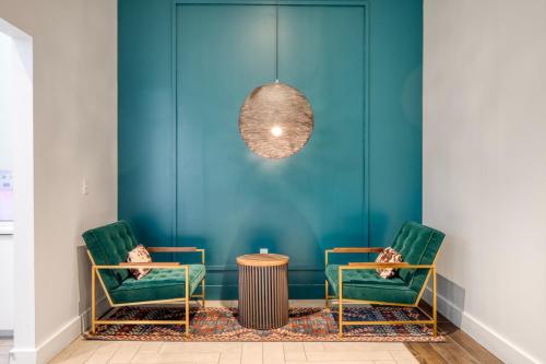 a room with two green chairs and a table at 1BR w Gym WD Steps from Newtonville Train BOS-353 in Newton