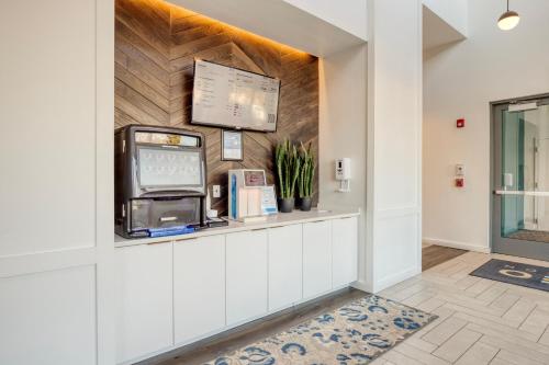 a lobby with a cash register and a tv on a wall at 1BR w Gym WD Steps from Newtonville Train BOS-353 in Newton