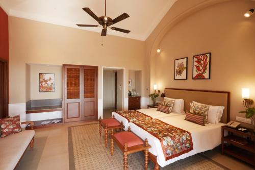 a bedroom with a large bed and a couch at Taj Holiday Village Resort & Spa, Goa in Candolim