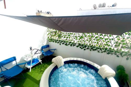 uma banheira de hidromassagem num cruzeiro com cadeiras e uma piscina em superbe appartement climat Centralisé avec Jacuzzi supplémentaires em Kenitra