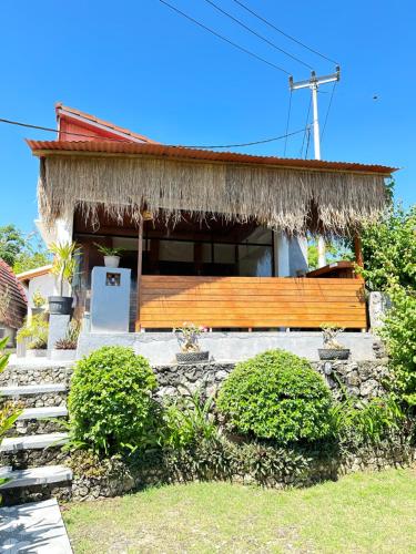 une maison avec un toit de chaume et des escaliers en face de celle-ci dans l'établissement Penida Hills Hostel, à Nusa Penida