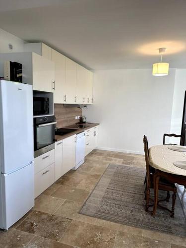 une cuisine avec une table et un réfrigérateur blanc dans l'établissement Château de la Folie, à Montfort-sur-Risle