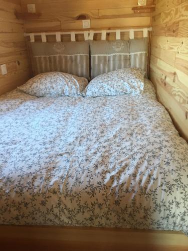 a large bed in a room with a wooden wall at LA ROULOTTE DE MOUCHOU in Saintes-Maries-de-la-Mer