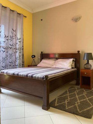 a bedroom with a wooden bed with a curtain at the bib By Jevas in Dar es Salaam