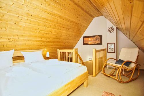 a bedroom with a large bed and a chair at idyllisches Ferienhaus mit eigener Sauna, Kamin und Terrasse - Haus Kranich in Vieregge