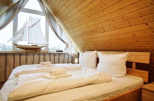 a bedroom with a bed with a sail boat in the window at idyllisches Ferienhaus mit eigener Sauna, Kamin und Terrasse - Haus Boddenblick in Vieregge