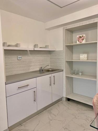 a kitchen with white cabinets and a sink at Q-Panzió in Tata