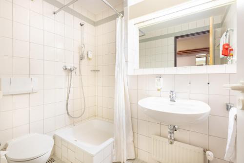 Un baño blanco con lavabo e inodoro. en acora Leipzig Living the City - Apartments, en Leipzig
