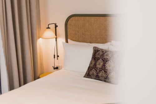 a bed with a pillow and a lamp on it at The Sarah by Urban Rest in Sydney