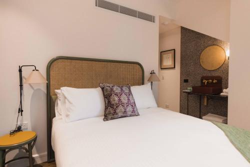 a bedroom with a white bed with a pillow on it at The Sarah by Urban Rest in Sydney