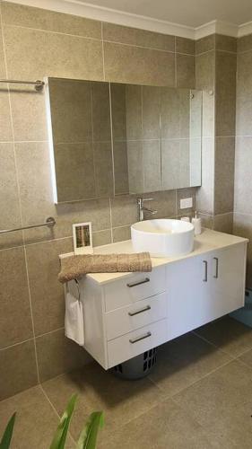 a bathroom with a white sink and a mirror at Nunyara Retreat. Quality bush retreat in Wolfdene