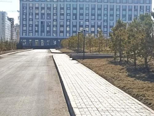 eine leere Straße vor einem großen Gebäude in der Unterkunft Двухкомнатная квартира in Promyshlennyy