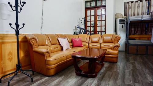 a living room with a leather couch and a table at Cao Bang Eco Homestay in Cao Bằng