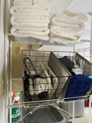 a drying rack with towels and a sink in a room at DL505 Inn surrounded by Japanese retro furniture in Toyohira