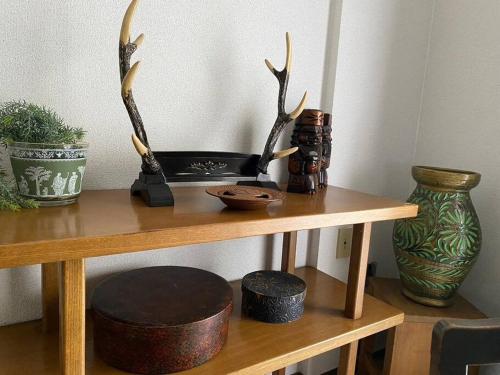 a table with antlers and a vase on it at DL505 Inn surrounded by Japanese retro furniture in Toyohira